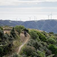 A mountain biker rides along a track on a mountain range.