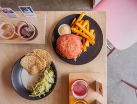 A table set with two beer flights and two plates of food shot from above.