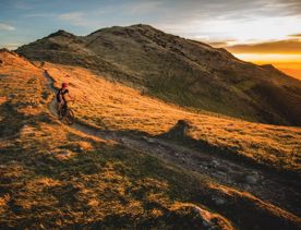 A cyclist wearing a red helmet rides along the Skyline Walkway, a trail in Wellington, New Zealand.