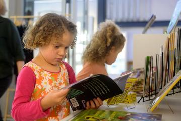 Two kids look at books in a museum gift shop.