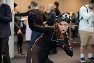 A person demonstrating a gamer suit at the 2022 NZGDC Game Developers Conference at Te Papa in Wellington.