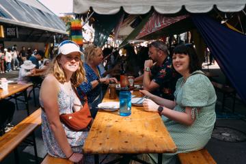 Four people are eating at a picnic table.