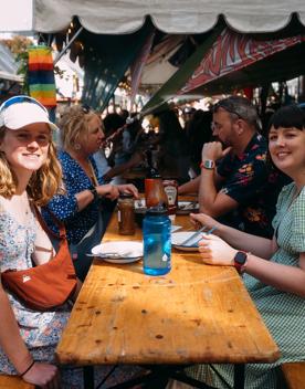 Four people are eating at a picnic table.