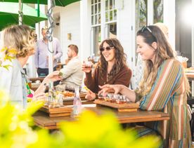 Three friends enjoy food and drinks on the patio at The White Swan in Greytown.