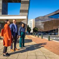 Three people stand outside Te Papa looking across the street.