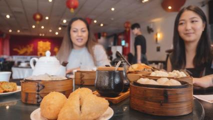 Two people eat dumplings at a Chinese restaurant.