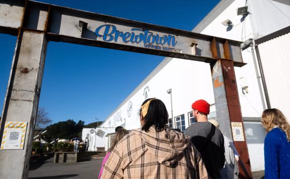 Group of people walking under Brewtown sign in Upper Hutt.