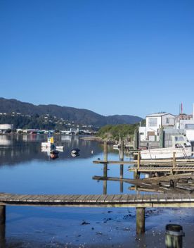 The Petone boat ramp, Hikoikoi,  with colourful boat sheds and boats in the morning sun.