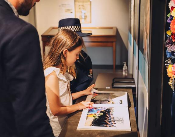 A young child looking through a book at the new Zealand police museum.