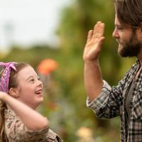 A still from the movie ‘Poppy’ where Poppy played by Libby Hunsdale high-fives Dave played by Ari Boyland.