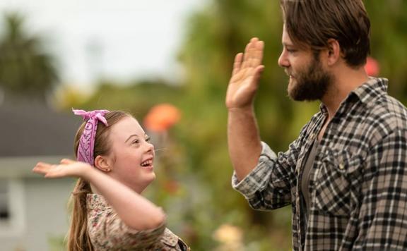 A still from the movie ‘Poppy’ where Poppy played by Libby Hunsdale high-fives Dave played by Ari Boyland.