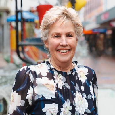 Headshot of Jill Hatchwell, a board member of WellingtonNZ, smiling in front of the Bucket Fountain.