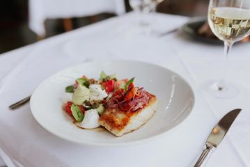 A dish with a fish fillet and assorted vegetables at Shed 5.