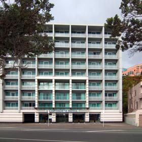 The exterior of Copthorne Hotel, a square shapes building with blue windows, 8 stories tall, and the road in front.