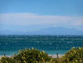 Snow capped mountains of the South Island pictured from the Wainuiomata Connector Ride trail, looking across the Cook Strait.