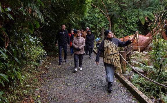 People walking along the path at the Pūkaha Wildlife Centre, guided by a local iwi member on Te Hīkoi o Pūkaha.