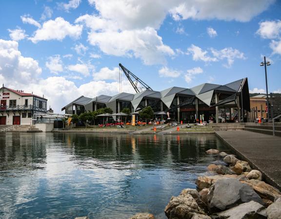 The exterior of Karaka Cafe at Te Wharewaka o Pōneke over the water.