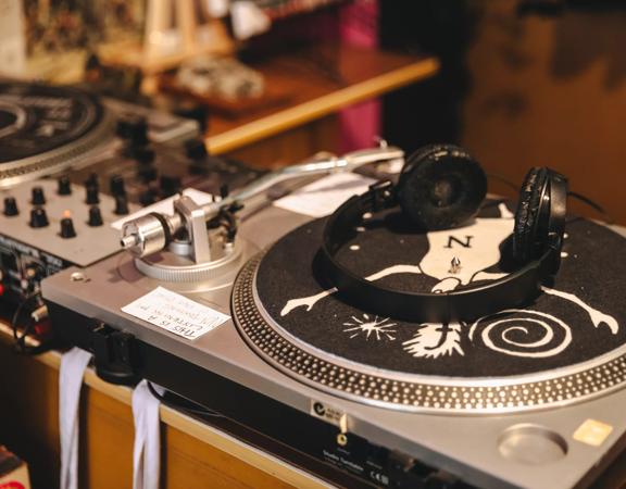 A vinyl record player with a pair of headphones laying on top at Xreeps Record Parlour, a record store in Petone, Lower Hutt, New Zealand.