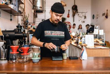 Barista at pour and twist creating their custom coffee on the counter.