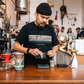 Barista at pour and twist creating their custom coffee on the counter.