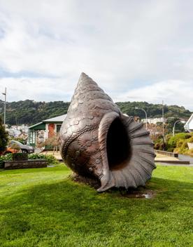 A 4-metre-high bronze sculpture of a conch shell on Pukeahu National War Memorial park grass, called Te Reo Hotunui o Te Moana Nui a Kiwa. (The Deep Sigh of the Pacific).