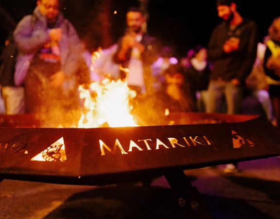 A photo of a Matariki torch burning at Matariki Ahi Kā