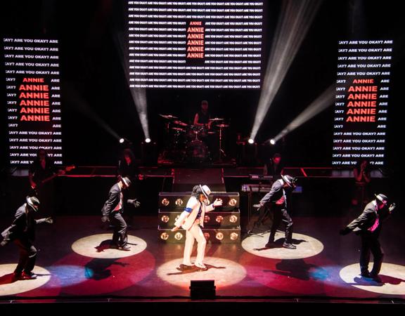 A Michael Jackson tribute show concert. Michael dances centre-stage with four backup dancers and a five-piece band.