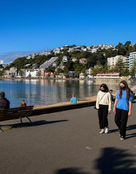 The screen location of Oriental Bay, wth pastel-coloured, Art Deco apartments, brightly-painted boat sheds, and the golden beach.