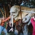 3 people outside Wētā workshops, poking swords at a hill troll from Lord of the Rings.