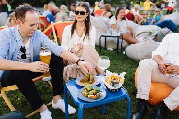 A group of friends enjoy drinks and appetizers on the lawn at St. Johns Bar & Eatery.