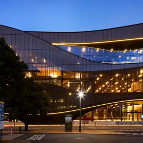 Exterior of the Tākina Convention & Exhibition centre showing the glass bronze coloured facade.